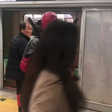 Man in red deadpool costume on nyc train