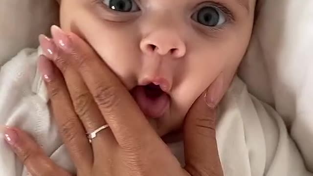 Cute little baby trying to sing along with mummy