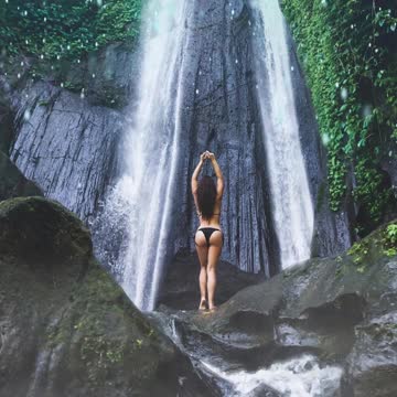 Amazing waterfall view - beautiful woman in bikini