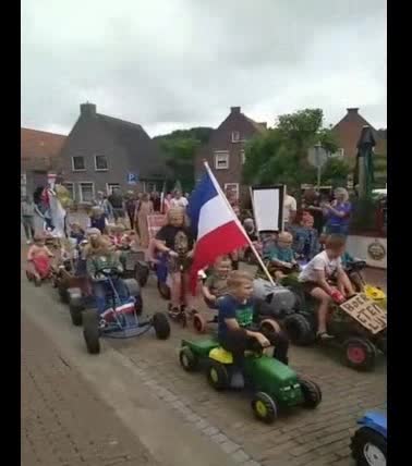 Children of the Netherlands joining the farm convoy riding their bikes behind tractors