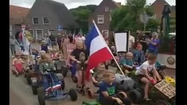 Children of the Netherlands joining the farm convoy riding their bikes behind tractors