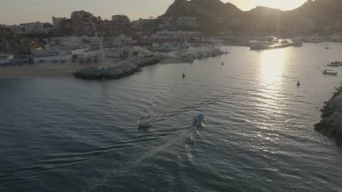 Aerial shot of a boat moving away from a coast