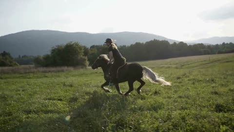 Girl is riding a horse on the meadow