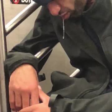 Guy backwards blue hat sleeping on subway drooling