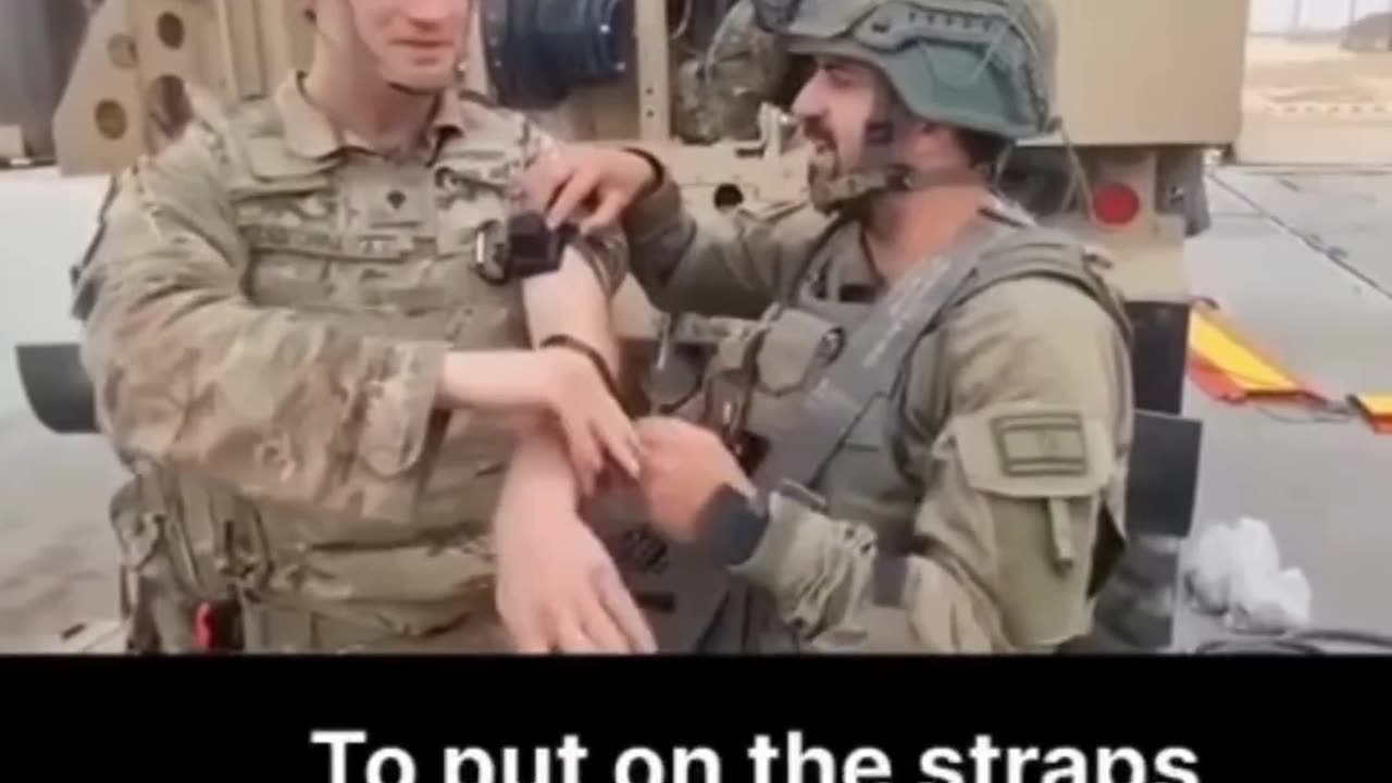 A US soldier in Gaza is wrapped with Tefillin straps by an Israeli soldier