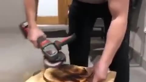 Man removing burnt pizza with grinder