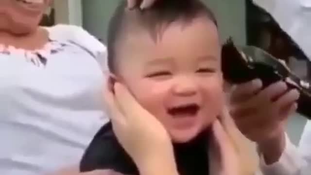 See how the baby is smiling while cutting the hair।