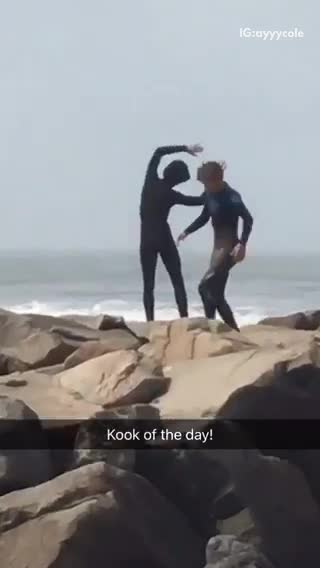 Surfer doing stretches on a rocky shore
