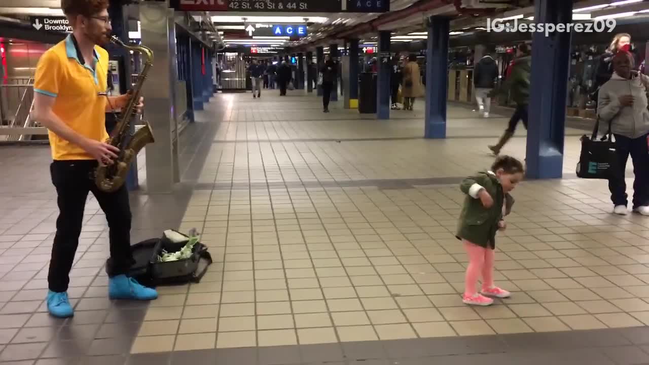 Little girl green jacket dances to jazz music