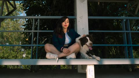 Woman with dog sitting on balcony