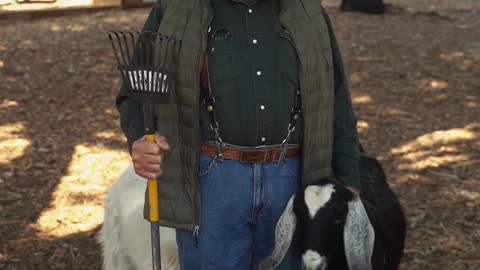 an-old-man-standing-beside-a-goat