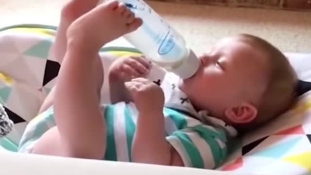 TODLER HOLDING HIS BOTTLE BY TWO LEGS.mp4