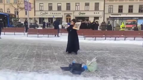 Woman burns Koran in Stockholm calling for a ban on Islam in Sweden and Europe.