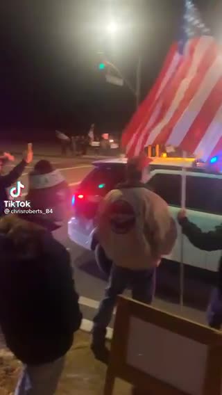 A police officer announces “Let’s go Brandon”