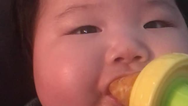 Baby eating tangerine or orange