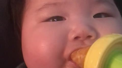 Baby eating tangerine or orange