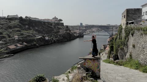 A Woman Dancing On a Concrete Ledge