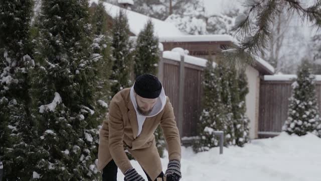 A Man Chopping Firewood Under Blizzard