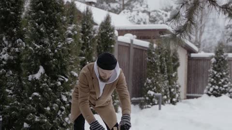 A Man Chopping Firewood Under Blizzard