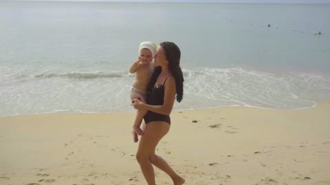 Mom and daughter dancing in the beach