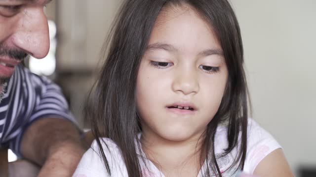 A pretty daughter playing with her father