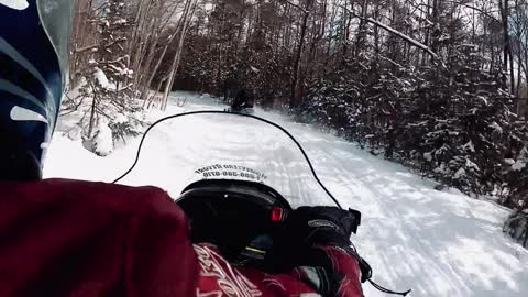 Riding a Snowmobile in the Mountains of Canada