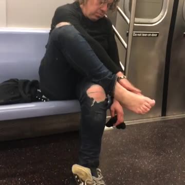 Old woman touching bare feet