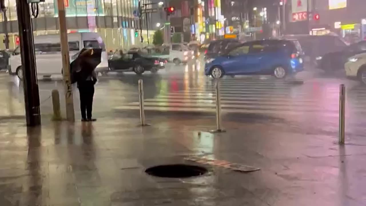 Water shoots out of a manhole near Shinjuku station in Tokyo, Japan