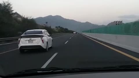 a car with a beautiful noon scene/driving to the foot of mountain