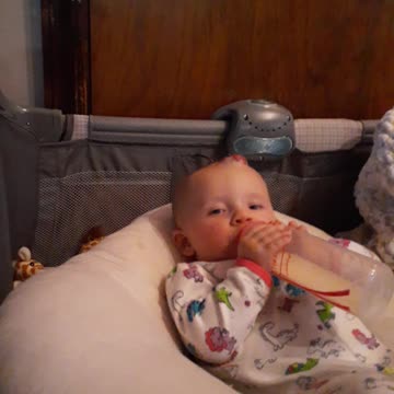 Baby girl holding her bottle