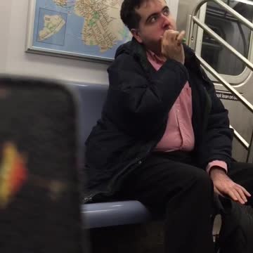 Man in red button up brushes teeth on subway