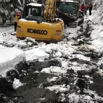 Excavator in deep rescuing a Groomer!