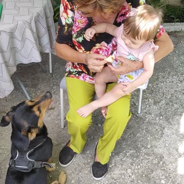 Family Tenderness: A woman nursing a dog and a baby