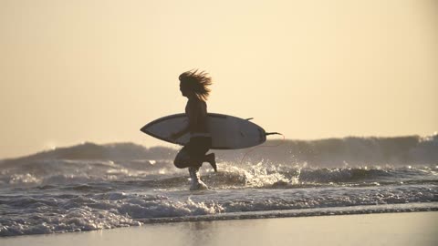 Surfer Running Along a Beach