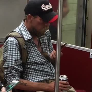 Man button down blue shirt canada black cap on phone lets rat crawl down shirt