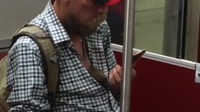 Man button down blue shirt canada black cap on phone lets rat crawl down shirt