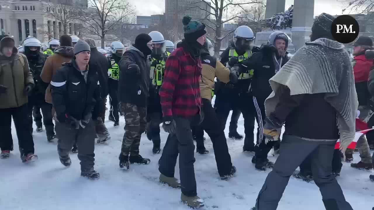 A huge line of police officers march to clear freedom protestors, deploying teargas