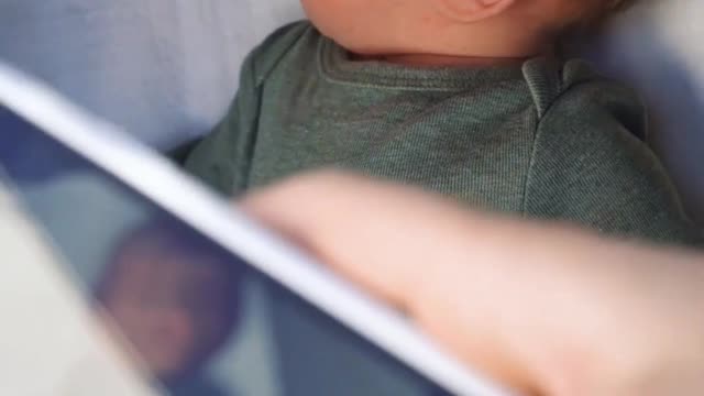 Person Taking a Picture of the Baby from the Phone