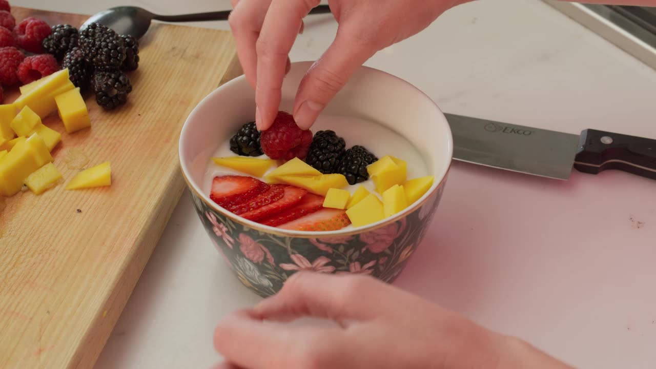 Preparing a bowl with yogurt and fruit