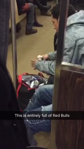 Guy has bag full of red bulls, opens a can a drink one