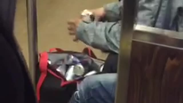 Guy has bag full of red bulls, opens a can a drink one