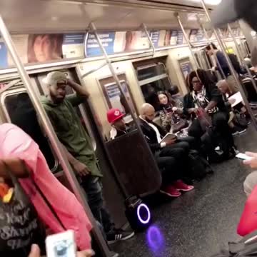 Man and woman dance perform on subway train