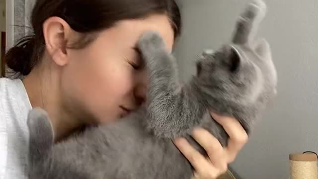 A woman is sucking on her cat