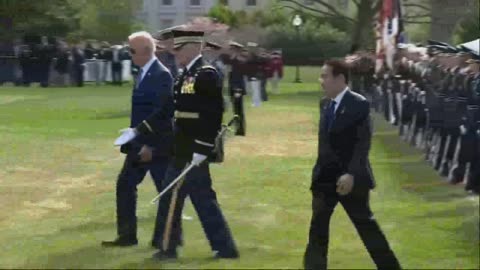 Biden does his signature shuffle as he's led around the White House lawn.