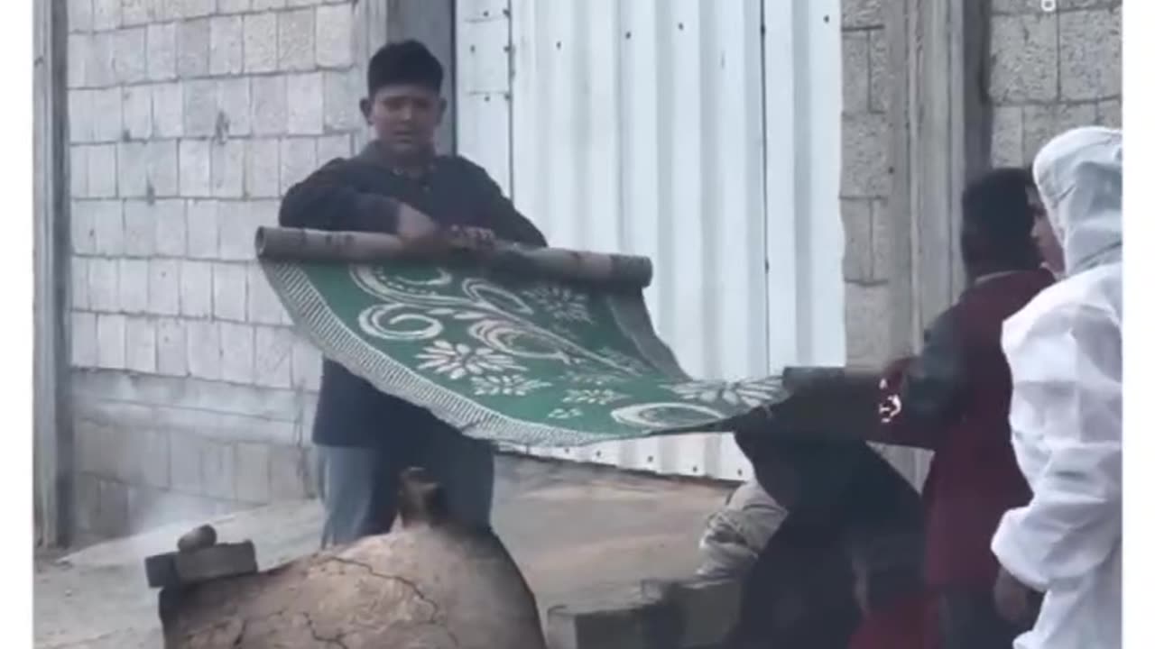 ►🚨▶◾️🇮🇱⚔️🇵🇸 ◾️Rafah children shielding mother from rain as she bakes bread