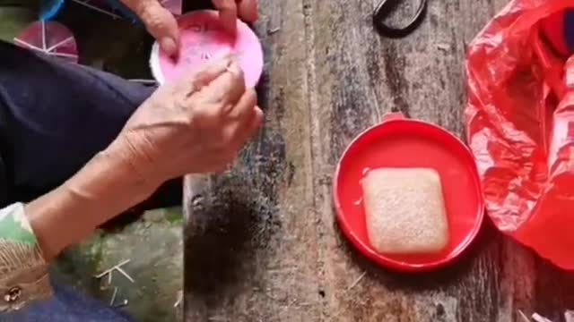 old women making small paper umbrella