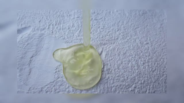 Slow Motion Of An Egg Yolk Falling On A Pile Of Flour