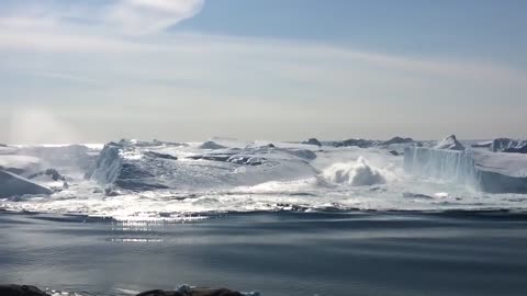 Ilulissat Icefjord - Large iceberg breaking over