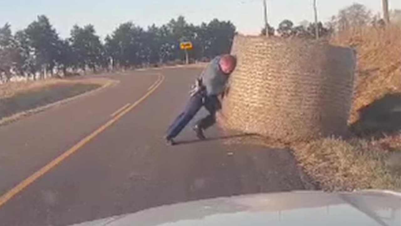 A state trooper got his leg workout in for the day moving this big hay bale out of the road!