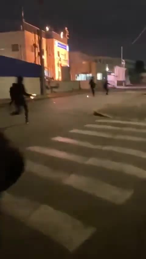 Young Palestinians throw Molotov cocktails at an Israeli police station